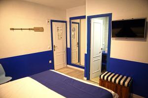 a bedroom with blue walls and a bed and a tv at Hostal Miranda in Blanes