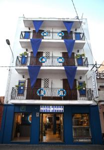 un edificio con banderas azules colgando de él en Hostal Miranda en Blanes