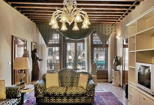 un soggiorno con divano e lampadario pendente di B&B San Firmino a Venezia