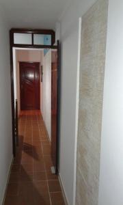 a hallway with a door and a tile floor at Apartamento frente ao mar Florida Praia Grande in Praia Grande