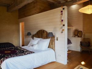 um quarto com uma cama branca e uma parede de madeira em Le Manoir du Pont Senot em Noron-la-Poterie