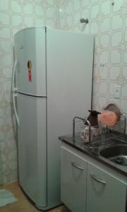 a white refrigerator in a kitchen with a sink at Apartamento frente ao mar Florida Praia Grande in Praia Grande