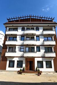 un edificio alto de color blanco con puerta de madera en Boutique Villa Arte en Ohrid