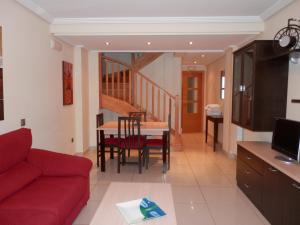 a living room with a red couch and a table at Apartamentos Monte Hernanz in Riaza