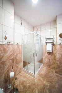 y baño con ducha y puerta de cristal. en Hotel Imperial Inn, en Târgu Mureș