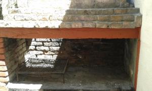 una chimenea de ladrillo con un banco frente a ella en Playa 1, en Villa Gesell