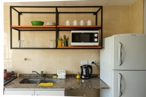 a kitchen with a sink and a white refrigerator at Departamento Salta in Salta