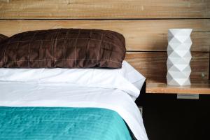 Cama con almohada marrón y cabecero de madera en Departamento Salta en Salta