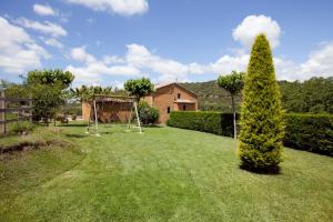 un árbol en un patio con un columpio en Cal Colom, en Puig-reig