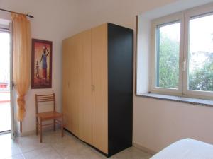 a cabinet in a bedroom with a chair and a window at Villa Riviera dei Gelsomini in Monasterace