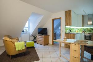 a living room with a table and a kitchen at Weingut Leininger Ferienwohnungen in Eibelstadt