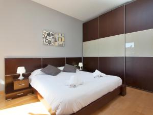 バルセロナにあるRentBCN Rambla Catalunya Apartmentのベッドルーム1室(白い大型ベッド1台、茶色の壁付)