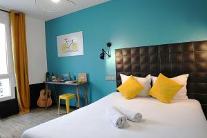a bedroom with a large bed with yellow and blue walls at Arty Paris Porte de Versailles by River in Paris