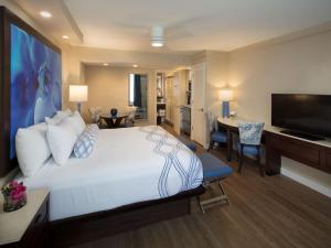 a bedroom with a large bed and a living room at Lido Beach Resort - Sarasota in Sarasota
