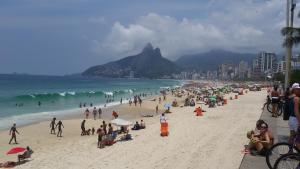Un grupo de personas en una playa con el océano en Anexo Ipanema, en Río de Janeiro