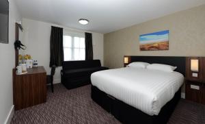 a hotel room with a bed and a chair at Willows, Blackburn by Marston's Inn in Blackburn +26 photos