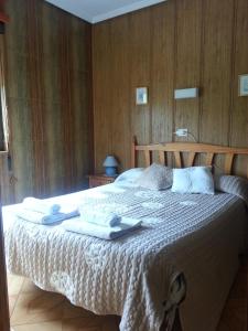 a bedroom with a large bed with towels on it at Hostal La Collada de Aralla in Aralla de Luna