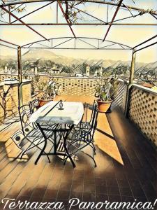 eine Terrasse mit einem Tisch und Stühlen auf dem Balkon in der Unterkunft Il Giardino Segreto di Ascoli Piceno in Ascoli Piceno