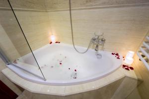 a bathroom with a bath tub with a candle in it at Ventus Rosa Apartments in Kraków