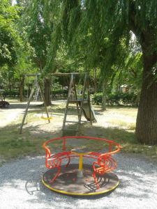 a playground in a park next to a tree at Camping Les Grillons in Embrun +32 photos