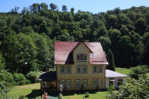 a large yellow house with a red roof at Pension Waldfrieden in Thale