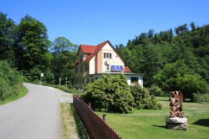 une maison avec une clôture à côté d'une route dans l'établissement Pension Waldfrieden, à Thale