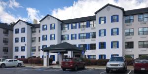 a large white building with cars parked in a parking lot at InTown Suites Extended Stay Marietta GA - Town Center in Kennesaw