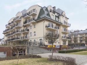 a large white building with stairs and balconies at VacationClub - Trzy Korony Wazow Apartment 12 in Świnoujście