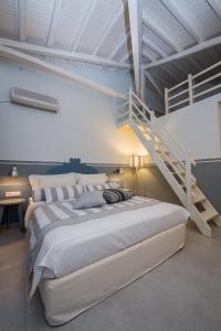 a bedroom with a large bed and a staircase at Alkyon Hotel in Patitiri
