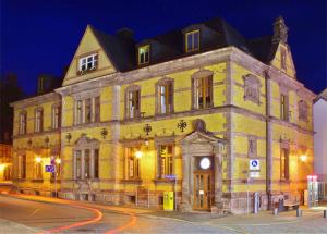 a large yellow brick building on a street at night at Alte Post Sondershausen in Sondershausen