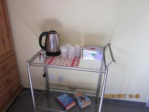 a tea kettle and mugs on a glass shelf at Luba Rube in Rust