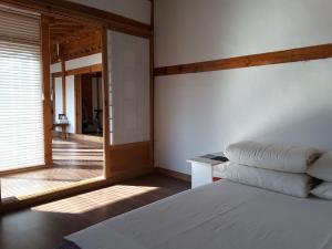 a bedroom with a bed and a large window at Yettle Hanok Stay in Gyeongju
