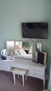 a white desk with a tv on top of it at Warwick Lodge in Carlisle