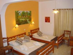 Zimmer mit 2 Betten, einem Tisch und Stühlen in der Unterkunft Boussetil Rooms CapAnMat in Tinos