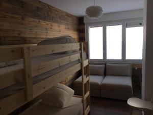 um quarto com um beliche e um sofá em Appartement Noécie em Les Crosets