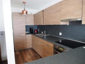 uma cozinha com armários de madeira e um lavatório em Appartement Noécie em Les Crosets