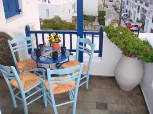 a blue table and chairs on a balcony at Boussetil Rooms CapAnMat in Tinos