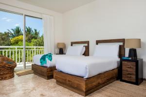 1 dormitorio con 1 cama y balcón en Sailrock South Caicos - Island Hop Flight Included, en Caicos del Sur