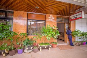a man standing in front of a building with plants at Sunshine Hotel Tengecha in Kericho