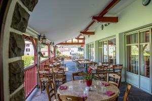 un restaurant avec des tables et des chaises sur un balcon dans l'établissement Logis Hotel Ur-Hegian, à Ainhoa