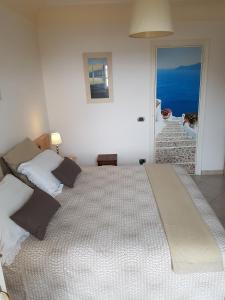 uma cama grande num quarto com vista para o oceano em B&B Il Tramonto em Anacapri