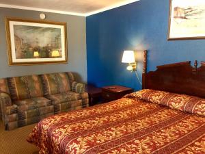a hotel room with a bed and a couch at Oasis Motel in Arlington