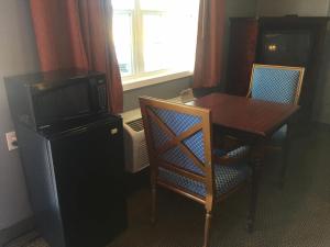 a room with a table and a television and a table and chairs at Oasis Motel in Arlington