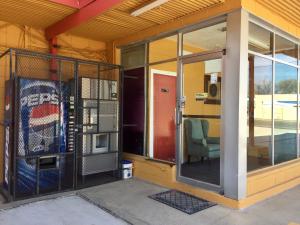 an open glass door on a building with a chair at Oasis Motel in Arlington