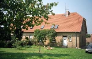 ein Backsteinhaus mit rotem Dach in der Unterkunft Ferienwohnung Rust in Warnitz