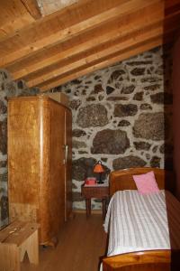 una camera da letto con un letto e un muro di pietra di Casa de Pedra a Viseu
