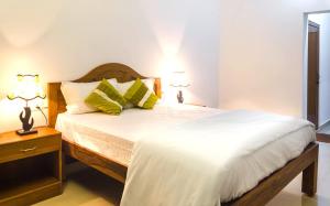 a bedroom with a large white bed with two lamps at Eve Resort in Patnem