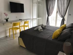 a bedroom with a bed with yellow chairs and a television at Dunant House in Rome
