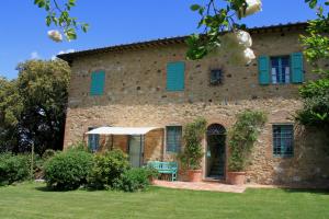 an old stone house with blue shutters on it at Podere San Luigi in San Gimignano