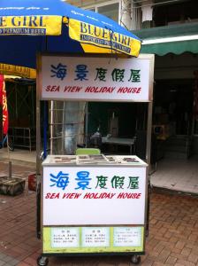 a hot dog stand with writing on it on a street at Sea View Holiday House in Hong Kong